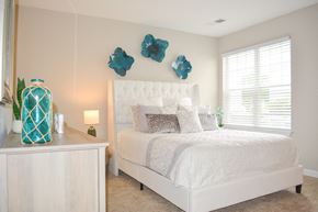Myrtle Beach apartment for rent - a bedroom with a white bed and blue flowers on the wall