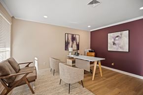Raleigh apartment for rent - A living room with a brown chair, a grey chair, and a white table.