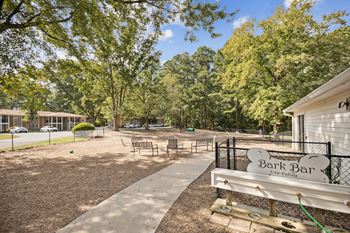 A park bench in front of a park with trees