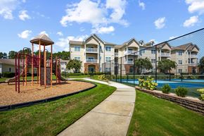 Carthage apartment for rent - A playground with a swing set and a building in the background.