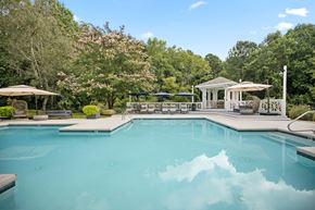 Cary apartment for rent - A large swimming pool surrounded by trees and a gazebo.