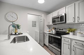 Cary apartment for rent - A modern kitchen with white cabinets and stainless steel appliances.