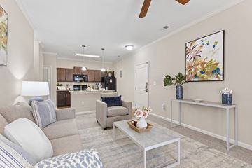 Raleigh apartment for rent - A living room with a grey couch, a coffee table, and a painting on the wall.