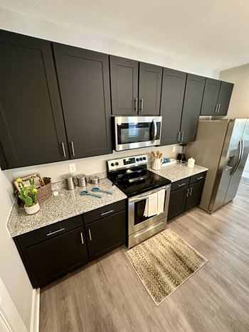 A kitchen with black cabinets and stainless steel appliances