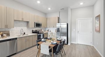 Glen Allen apartment for rent - A kitchen with a table set for two with a refrigerator and microwave above.
