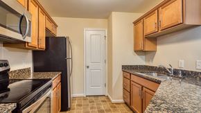 Forest apartment for rent - a kitchen with granite counter tops and wooden cabinets