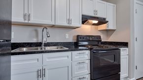 North Chesterfield apartment for rent - A modern kitchen with white cabinets and black countertops.