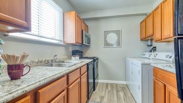Norfolk apartment for rent - A kitchen with wooden cabinets and a marble countertop.