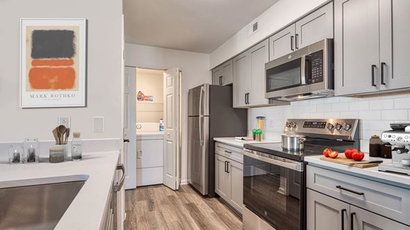 Virginia Beach apartment for rent - A modern kitchen with a refrigerator, oven, and microwave.