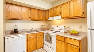 Roanoke apartment for rent - A kitchen with wooden cabinets and white appliances.