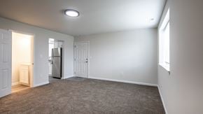 White Marsh townhouse for rent - an empty living room with white walls and a door to the kitchen