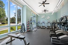 Raleigh apartment for rent - A gym with a variety of equipment including treadmills, weights, and a bench.
