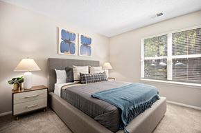 Charlotte apartment for rent - a bedroom with a bed and two windows