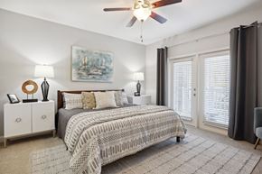 Charlotte apartment for rent - A bedroom with a large bed and a ceiling fan.