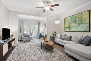Charlotte apartment for rent - A living room with a grey couch, a coffee table, a television, and a painting on the wall.