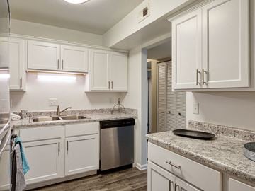 Williamsburg apartment for rent - A kitchen with white cabinets and a granite countertop.