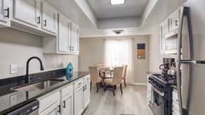Virginia Beach apartment for rent - a kitchen with white cabinets and a sink and a table with chairs  at Bayville Apartments, Virginia Beach, VA