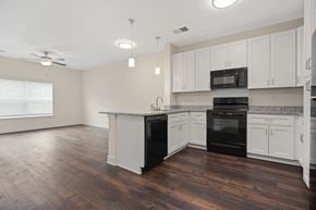 Raleigh apartment for rent - A kitchen with black appliances and white cabinets.