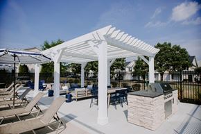 Sunbury apartment for rent - A white pergola is over a patio with chairs and a grill.