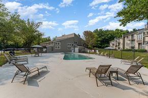 Greensboro apartment for rent - our apartments have a large pool and patio with chairs at Village 1373, Greensboro North Carolina