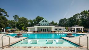 Yorktown apartment for rent - a swimming pool with lounge chairs and a club house in the background
