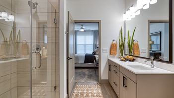 A bathroom with a shower and a sink and a mirror