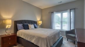 Lynchburg apartment for rent - A bedroom with a large bed, a chair, and two lamps.
