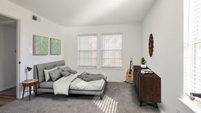 Virginia Beach apartment for rent - A bedroom with a bed, a nightstand, and a guitar.