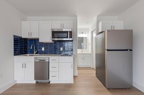 Charlotte apartment for rent - A kitchen with white cabinets and a blue tile backsplash.