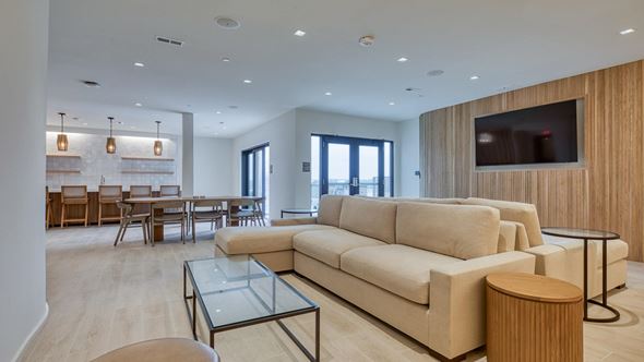 Virginia Beach apartment for rent - A modern living room with a glass coffee table and a large beige sofa.