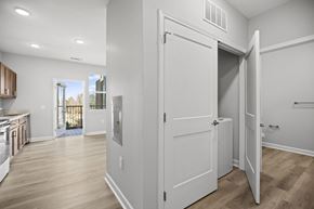 Charlotte apartment for rent - A white door is open in a room with wood flooring.