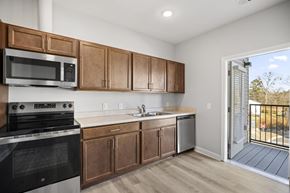 Charlotte apartment for rent - A kitchen with wooden cabinets and a black oven.