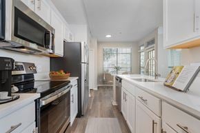 Dublin apartment for rent - A modern kitchen with white cabinets and a wooden floor. at The Orchard, Dublin, 43016