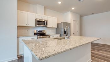 A kitchen with a granite counter top and a sink