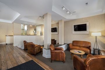 Dublin apartment for rent - A living room with brown leather chairs and a white reception desk.
