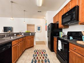 Petersburg apartment for rent - a kitchen with black appliances and wooden cabinets at Addison Crater Woods, Virginia, 23805