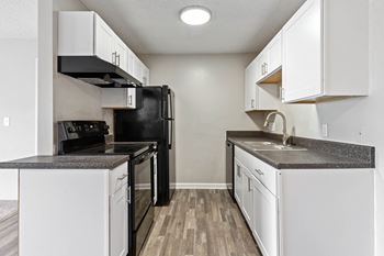 A kitchen with white cabinets and black appliances
