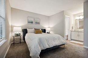 Greensboro apartment for rent - a bedroom with a bed and a bathroom in the background at Wendover River Oaks, Greensboro, NC