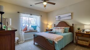 Virginia Beach apartment for rent - A bedroom with a bed, nightstand, and window.