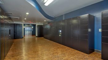 A long hallway with a blue wall and a brown floor.