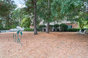 Pawleys Island apartment for rent - A playground with a swing set in the middle of a dirt area at Litchfield Oaks Apartments in Pawleys Island, South Carolina