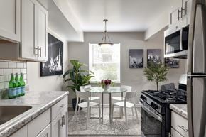 Windsor Mill apartment for rent - A kitchen with a table and chairs in the middle.