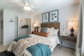 Southern Pines apartment for rent - A bedroom with a bed covered in a white and blue comforter.