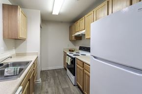 Williamsburg apartment for rent - A kitchen with a white refrigerator, wooden cabinets, and a stove top oven.
