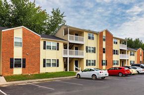 Williamsburg apartment for rent - A parking lot with cars and apartment buildings.