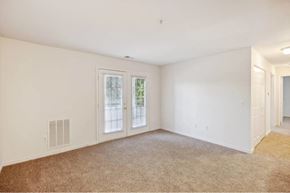 Richmond apartment for rent - A room with a carpeted floor and a window with a view of trees.