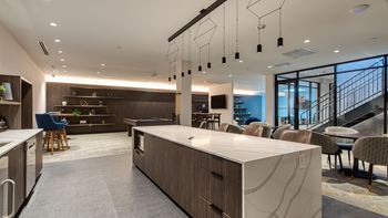 A large kitchen and dining area with chairs and a staircase