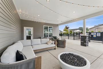 Post Falls apartment for rent - A modern outdoor living space with a grey sofa and a fire pit.