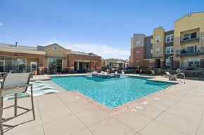 Broomfield apartment for rent - A pool surrounded by apartment buildings on a sunny day.