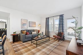 Broomfield apartment for rent - A living room with a grey couch, a coffee table, and a rug.
